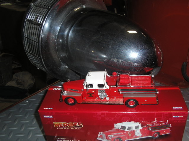 Model with box posed on the fender with the "Q" siren.